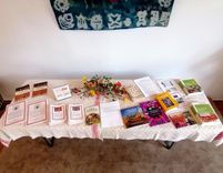 A table with books, brochures, and flowers.